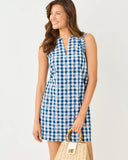 Woman wearing a blue and white checkered dress with a plain background