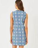 Woman wearing a blue and white checkered dress with butterfly pattern on a light gray background