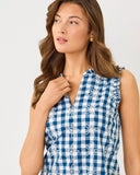 Woman wearing a blue and white checkered dress with floral details on a plain background